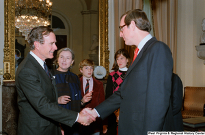 ["Senator John D. (Jay) Rockefeller shakes hands with Vice President George H. W. Bush following the Senate Swearing-In Ceremony."]%