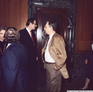 ["Senator John D. (Jay) Rockefeller speak with unidentified individuals following the Senate Swearing-In Ceremony."]%