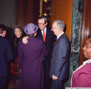 ["Senator John D. (Jay) Rockefeller embraces an unidentified woman in a purple dress after he has been sworn into office."]%