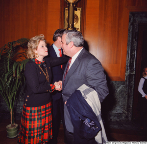 ["Sharon Rockefeller shakes the hand of a supporter at the Senate Swearing-In Ceremony. Senator John D. (Jay) Rockefeller can be partially seen in the background."]%