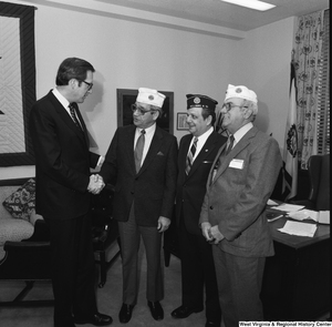 ["Senator John D. (Jay) Rockefeller shakes the hand of an unidentified member of the American Legion in his Washington, D.C. office."]%