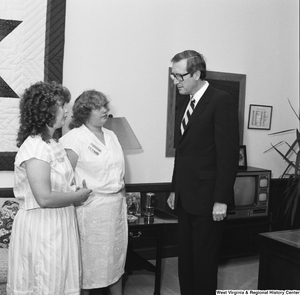 ["Senator John D. (Jay) Rockefeller speaks with two unidentified individuals in his office."]%