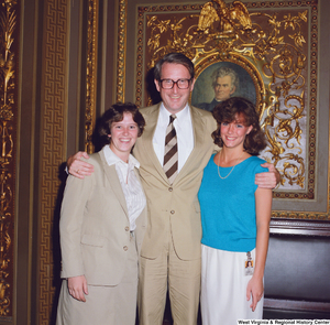 ["Senator John D. (Jay) Rockefeller poses for a photograph with two unidentified individuals in the President's Room outside the Senate."]%