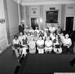 ["Senator John D. (Jay) Rockefeller stands for a photograph with a large group of senior citizens from Jefferson County, WV in a room in the Russell Senate office building."]%