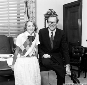 ["Senator John D. (Jay) Rockefeller and an unidentified woman smile and pose for a photograph in the Senator's Washington office."]%