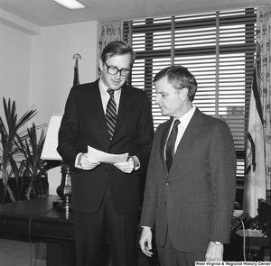 ["Senator John D. (Jay) Rockefeller holds a sheet of paper and speaks with the Assistant Director of FEMA, Sam Speck."]%