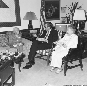 ["Senator John D. (Jay) Rockefeller shares a meal with two unidentified women in his Washington office."]%