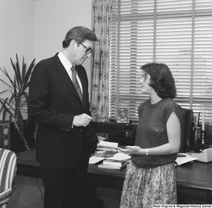 ["An unidentified woman speaks with Senator John D. (Jay) Rockefeller in his Washington office."]%