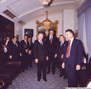 ["This color photograph shows several senators including Senators Robert C. Byrd and John D. (Jay) Rockefeller and former Senator Jennings Randolph stand together in a room outside the Senate to celebrate Senator Byrd's birthday."]%