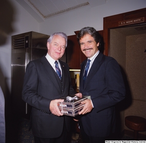 ["During his birthday celebration, Senator Robert C. Byrd receives a gift from a Senate colleague."]%