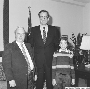 ["Senator John D. (Jay) Rockefeller stands in his office for a photograph with an unidentified boy and man."]%