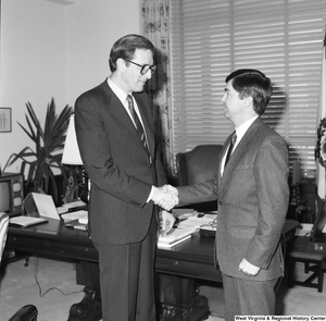 ["Senator John D. (Jay) Rockefeller shakes hands with an unidentified man in his office."]%