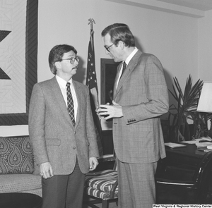 ["Senator John D. (Jay) Rockefeller speaks with an unidentified man in his office."]%