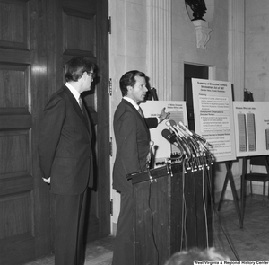 ["Senator John D. (Jay) Rockefeller stands next to Senator H. John Heinz III as he discusses the Dislocated Workers Improvement Act of 1987 at a press event."]%