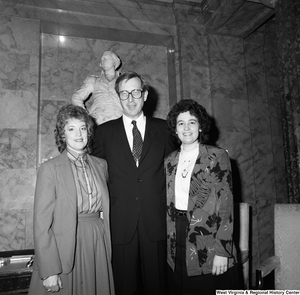 ["Senator John D. (Jay) Rockefeller stands between two unidentified women in front of a statue at a Senate building."]%