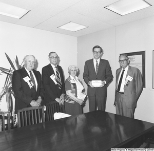 ["Senator John D. (Jay) Rockefeller stands for a photograph with four representatives of the American Association of Retired Persons. The Senator holds a box that reads \"First Aid for Medicare and Medicaid\"."]%