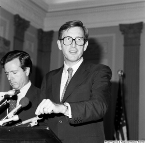 ["Senator John D. (Jay) Rockefeller smiles at his audience as he speaks about the Dislocated Workers Improvement Act. His cosponsor, Senator John Heinz, stands behind him."]%