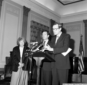 ["Senator John Heinz and an unidentified woman stand next to Senator John D. (Jay) Rockefeller as he speaks about the Dislocated Workers Improvement Act of 1987."]%