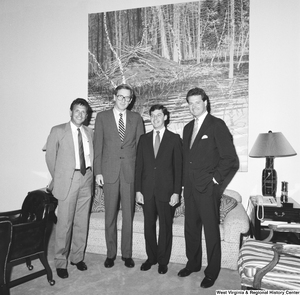 ["Senator John D. (Jay) Rockefeller poses for a photograph in front of a painting on the wall in his office with three representatives from the Huntington Group."]%