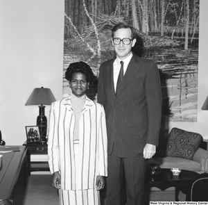 ["Senator John D. (Jay) Rockefeller stands next to an unidentified young woman in his office."]%