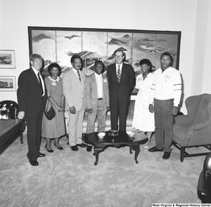 ["Senator John D. (Jay) Rockefeller stands among a group of unidentified individuals wearing NSTA/NASA badges."]%