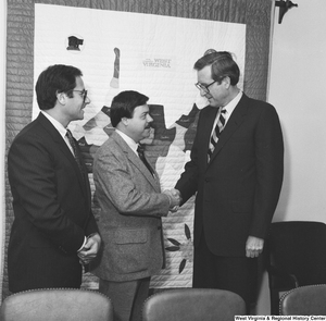 ["Senator John D. (Jay) Rockefeller shakes hands with a representative of the Beverage Industry Recycling Program."]%