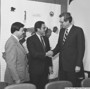 ["Senator John D. (Jay) Rockefeller shakes hands with a representative of the Beverage Industry Recycling Program."]%