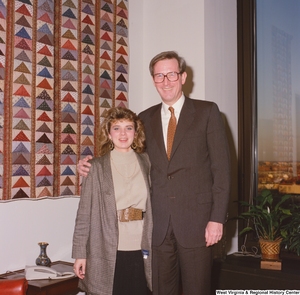 ["Senator John D. (Jay) Rockefeller stands next to an unidentified young woman in his office."]%