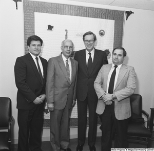 ["Senator John D. (Jay) Rockefeller stands with three unidentified men in his office."]%