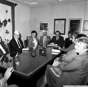 ["Senator John D. (Jay) Rockefeller sits at a conference table with members of the American Legion."]%