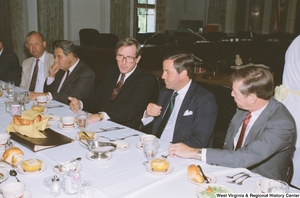 ["Senator John D. (Jay) Rockefeller speaks to an unidentified man during a reception event for American Electric Power."]%