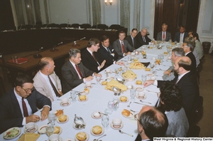 ["Senator John D. (Jay) Rockefeller sits and speaks to unidentified guests at a reception event for American Electric Power."]%