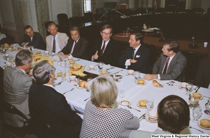 ["Senator John D. (Jay) Rockefeller speaks to an unidentified individual during a reception event for American Electric Power."]%