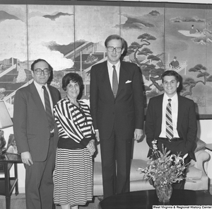 ["Senator John D. (Jay) Rockefeller stands between three unidentified individuals in his office."]%