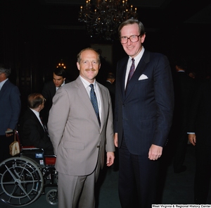 ["Senator John D. (Jay) Rockefeller stands next to an unidentified man."]%