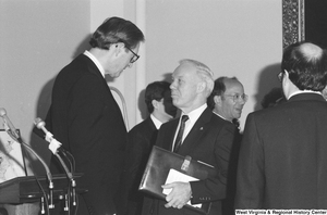 ["Senator John D. (Jay) Rockefeller speaks to an unidentified man after a press event."]%