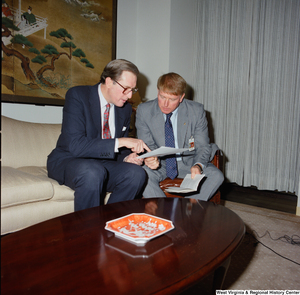 ["Senator John D. (Jay) Rockefeller points to a sheet of paper as he speaks with a man in his office."]%