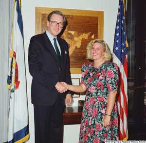 ["Senator John D. (Jay) Rockefeller shakes hands with a young woman in his office."]%