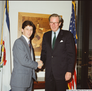 ["Senator John D. (Jay) Rockefeller shakes hands with a young man."]%