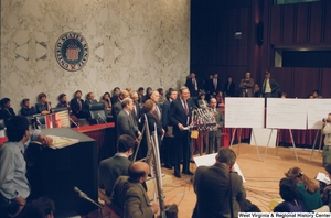 ["This is a wide angle photograph showing a row of staffers and Senators standing behind Senator John D. (Jay) Rockefeller as he speaks to the media during a press event for the Pepper Commission."]%