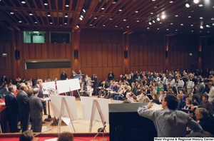 ["This photograph is a wide shot that shows a large room full of members of the media who are watching Senator John D. (Jay) Rockefeller speak during a Pepper Commission press conference."]%