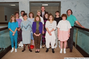 ["Senator John D. (Jay) Rockefeller stands with a group of students in the hallway of the Hart Building."]%