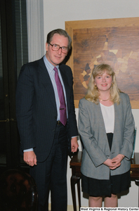 ["Senator John D. (Jay) Rockefeller stands beside a young woman, possibly an intern, in his office."]%