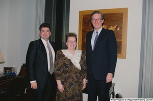 ["Senator John D. (Jay) Rockefeller stands next to two unidentified guests from Riverside Apostolic Church in his office."]%