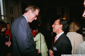 ["Senator John D. (Jay) Rockefeller speaks with an unidentified man at the Celebrating Telemedicine event in the Senate."]%