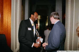 ["A healthcare professional laughs with Senator John D. (Jay) Rockefeller during the reception of the Celebrating Telemedicine conference."]%