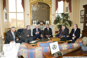 ["A group of Senators sit together during a small event."]%