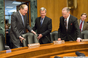 ["Senator John D. (Jay) Rockefeller helps pull out the chair for Senator Max Baucus at the beginning of a Senate Finance Committee hearing."]%