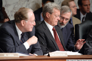 ["Senator Max Baucus is briefed on an issue by an adviser during a Finance Committee hearing."]%