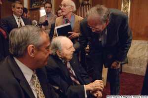 ["Senator John D. (Jay) Rockefeller speaks with a man after an Energy Committee hearing."]%